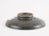 an old black vase sitting on top of a white surface