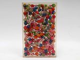brightly colored lollipops in a clear box on a white surface