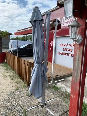un parapluie bleu posé sur un support à l'extérieur