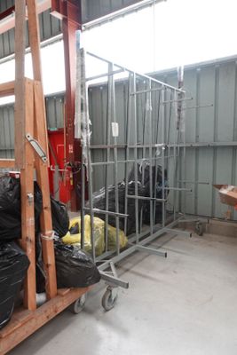 Plusieurs sacs de bagages sont empilés sur un chariot dans un entrepôt.