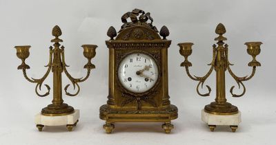 trois bougies et une horloge posées sur une table