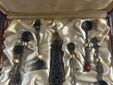trois cuillères en argent dans une boîte recouverte d'un tissu doré