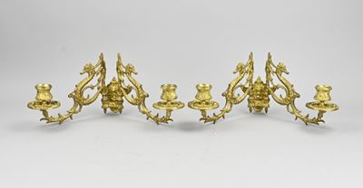 a set of four antique brass candlesticks on a white background