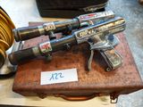 two guns that are sitting on top of a wooden box
