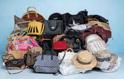 une pile de sacs à main et de chapeaux posée sur une table