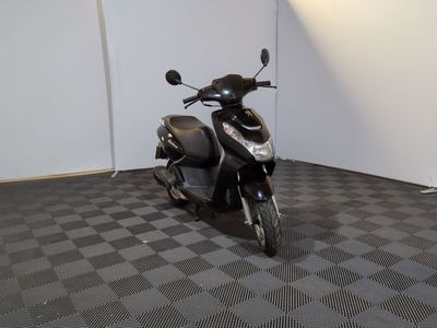une moto garée dans une pièce au sol en damier