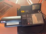 a calculator sitting on top of a desk next to a laptop