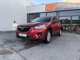 une Mazda CX-5 rouge garée devant un immeuble