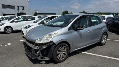 une voiture argentée garée sur un parking, avec d'autres voitures en arrière-plan