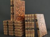several old books stacked on top of each other on a table