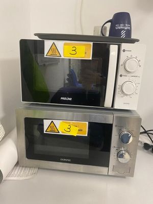 deux micro-ondes posés l'un sur l'autre sur une table