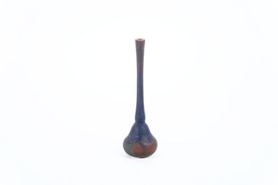 a small blue vase sitting on a white surface