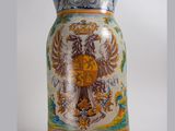 a vase with a picture of a coat of arms on it