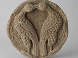 une image représentant une sculpture en pierre représentant deux oiseaux posés sur un socle circulaire