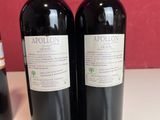 two bottles of wine sitting on top of a table next to each other