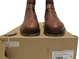 La boîte est marron et il y a une paire de chaussures posée dessus.