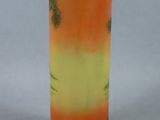 an orange and green vase sitting on top of a green base