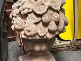 un vase en pierre surmonté d'un bouquet de fleurs