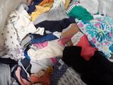 a pile of clothes that is on a bed