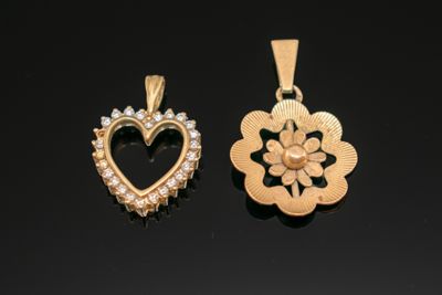 deux pendentifs en forme de cœur, en or et diamants, sur un fond noir