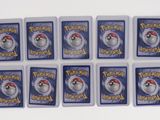 six pokemon trading cards with a red and white hat on top of them