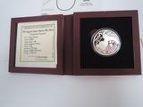 a silver coin in a wooden box on a table