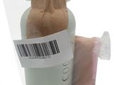 a bottle of soap and a bag of toilet paper on a white surface