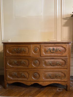 une commode en bois posée dans un coin de la pièce