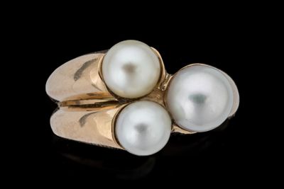 trois bagues ornées de perles sur une surface noire, avec un fond noir