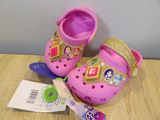 a pair of pink crocs on a wooden table