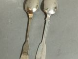 two spoons that are sitting next to each other on a table