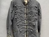 une vieille veste accrochée au mur à côté d'un cintre en bois