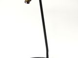 une lampe posée sur un pied, sur une surface blanche