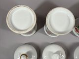four plates and two cups and a bowl on the table