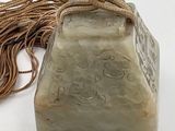 a stone with a rope around it on a white surface