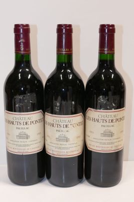 trois bouteilles de vin rouge sont alignées sur une surface blanche