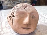 une sculpture en argile représentant un visage, posée sur une table