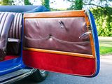 a close up of a car door with a brown leather seat