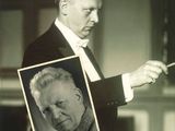 photographie en noir et blanc d'un homme en smoking tenant une photo de lui-même