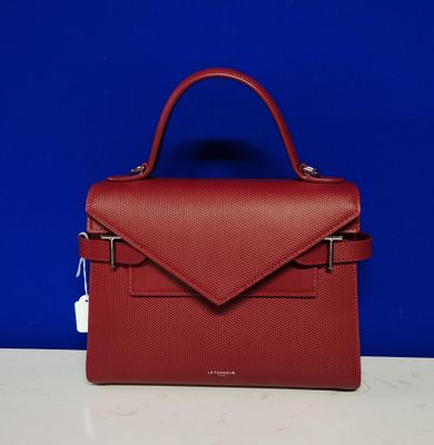 un sac à main rouge posé sur une table blanche