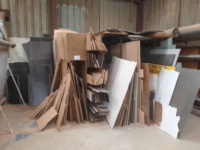 a large pile of cardboard and cardboard boxes in a warehouse