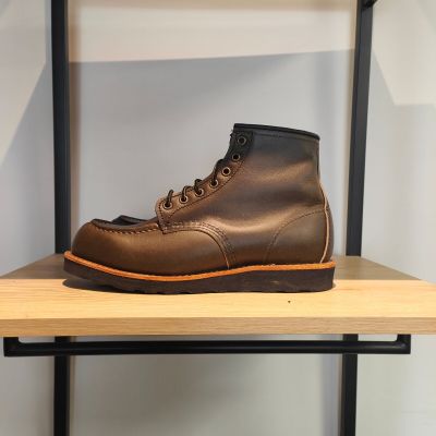 une paire de bottes marron posée sur une étagère en bois