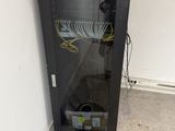 a black cabinet with a glass door and a bucket of water