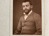 an old photo of a man with a beard in a suit and tie