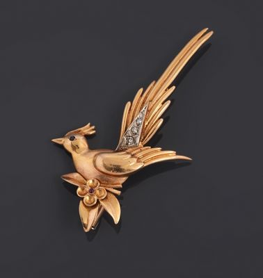an image of a gold bird broochle with a diamond in its beak