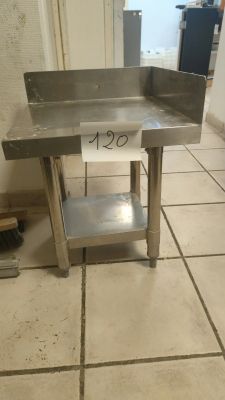 a stainless steel sink on a tile floor in a kitchen