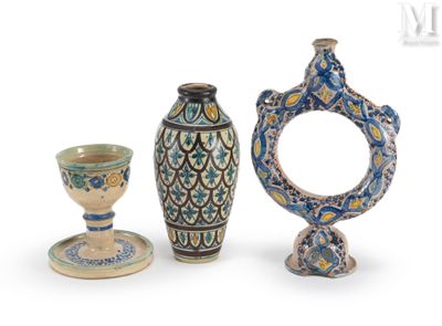 trois vases et une tasse posés sur une surface blanche