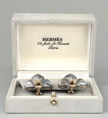 pair of silver and gold cufflinks in a box
