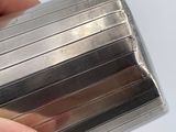 a woman holding a silver cigarette case with red nail polish