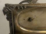 a silver clock sitting on top of a table